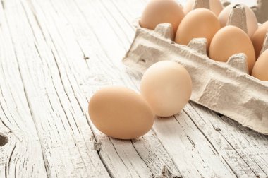 tavuk yumurtası Beyaz ahşap zemin üzerine karton kutu içinde