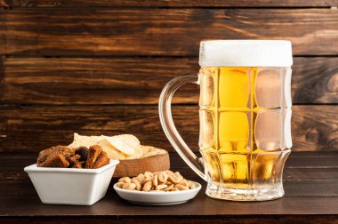 bardak soğuk köpüklü lager bira ve ahşap masa snacks