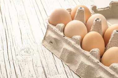 tavuk yumurtası Beyaz ahşap zemin üzerine karton kutu içinde