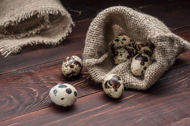 çuvala eski ahşap arka plan üzerinde bıldırcın yumurtası