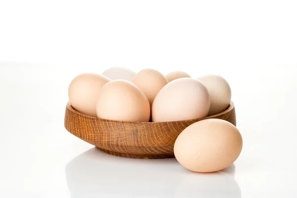 Chicken eggs in a wooden plate isolated on white background — Stock Photo, Image