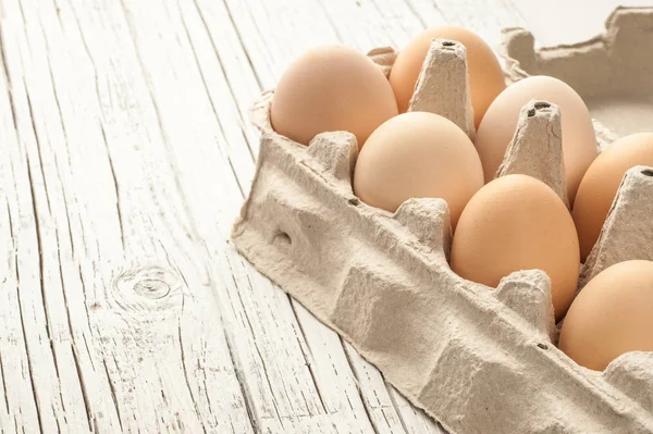 tavuk yumurtası Beyaz ahşap zemin üzerine karton kutu içinde
