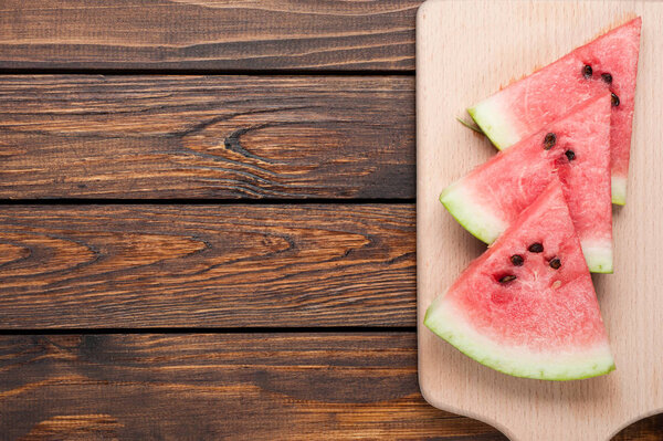 ломтики арбуза на темном деревянном фоне
