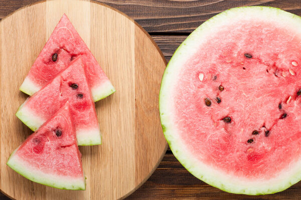 арбуз нарезанный на темном деревянном фоне
