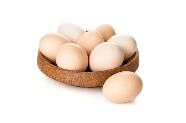 Chicken eggs in a wooden plate isolated on white background — Stock Photo, Image