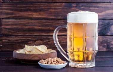 bardak soğuk köpüklü lager bira ve ahşap masa snacks