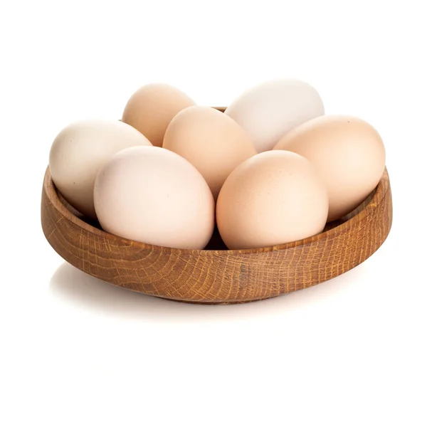 Chicken eggs in a wooden plate isolated on white background — Stock Photo, Image