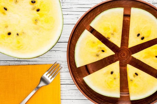 Gele Watermeloen slices op plaat op de top van de witte houten achtergrond — Stockfoto
