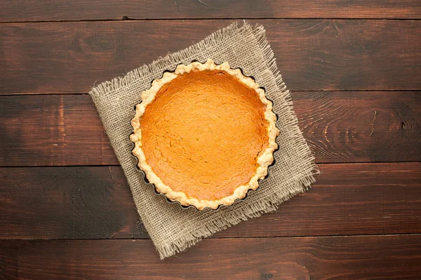 Zelfgemaakte pompoenpastei bij houten achtergrond versierd met jute — Stockfoto