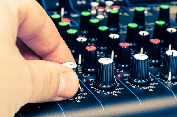 Man's hand adjusting mixing console knobs close-up — Stock Photo, Image