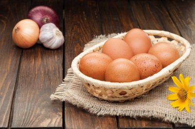 ahşap masa üzerinde soğan tavuk yumurtası sepet içinde süslenmiş 