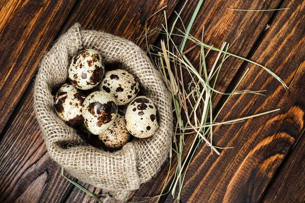 çuvala eski ahşap arka plan üzerinde bıldırcın yumurtası üzerinde Üstten Görünüm