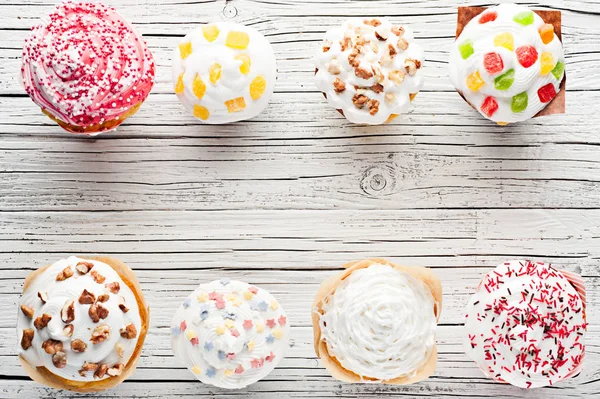 Verscheidenheid van cupcakes op witte houten achtergrond bovenaanzicht — Stockfoto