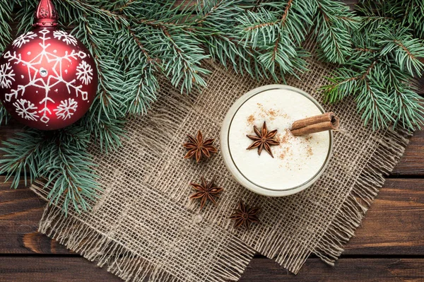 Eggnog cocktail in glass arranged with christmas decoration on w — Stock Photo, Image