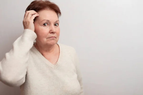 Mujer adulta sobre un fondo blanco en un suéter ligero. Emociones —  Fotos de Stock