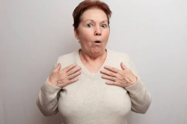 Mulher adulta em um fundo branco em uma camisola leve. Emoções — Fotografia de Stock