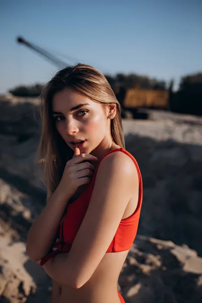 Bella ragazza dai capelli biondi in costume da bagno rosso sulla spiaggia — Foto Stock