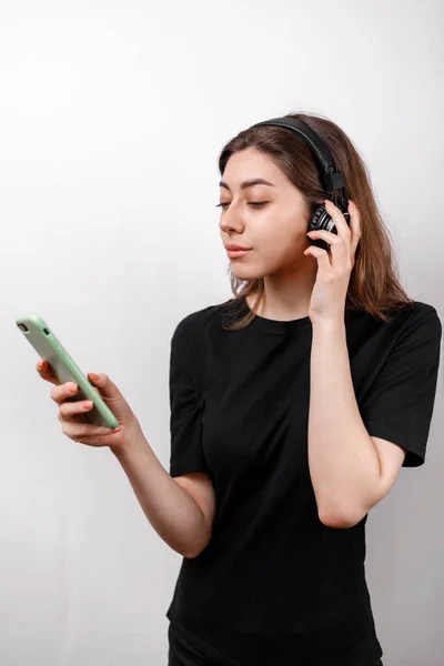 Ung Brunett Kvinna Svart Shirt Vit Bakgrund Lyssnar Musik Med — Stockfoto