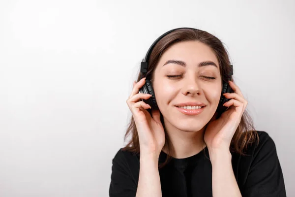 Mutlu Esmer Kadın Beyaz Arka Planda Kulaklıkla Müzik Dinlerken Gülümsüyor — Stok fotoğraf