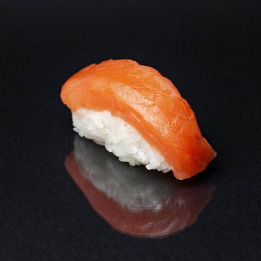 Siyah bir zemin üzerinde yansıması olan çeşitli lezzetli suşi ruloları. menü