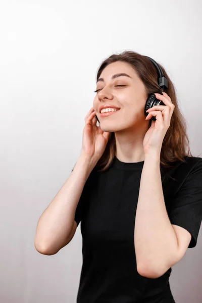 Mutlu Esmer Kadın Beyaz Arka Planda Kulaklıkla Müzik Dinlerken Gülümsüyor — Stok fotoğraf