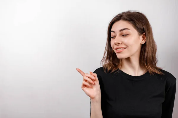 Sorrindo Jovem Morena Mostra Dedo Para Lado Fundo Branco Isolado — Fotografia de Stock