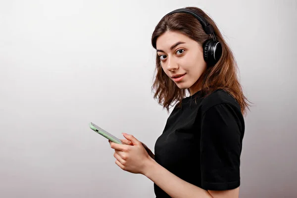 Ung Brunett Kvinna Svart Shirt Vit Bakgrund Lyssnar Musik Med — Stockfoto