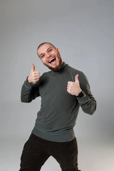 Joven feliz en una camiseta sobre un fondo blanco. emociones — Foto de Stock