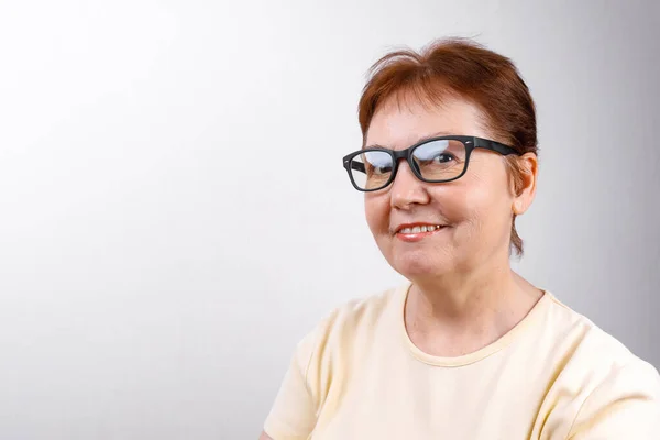 Senior Woman Looks Away Glasses White Background Light Shirt Place — Stock Photo, Image