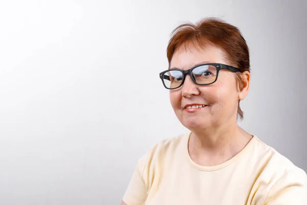 Die Seniorin Blickt Mit Brille Auf Weißem Hintergrund Und Hellem Stockbild