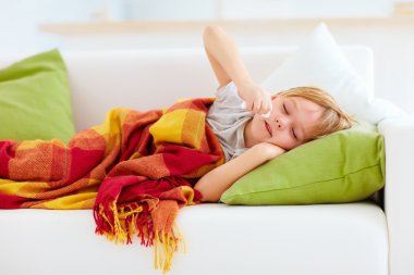 Çocuk burun akıntısı ile hasta ve ısı evde kanepede yatan ateş