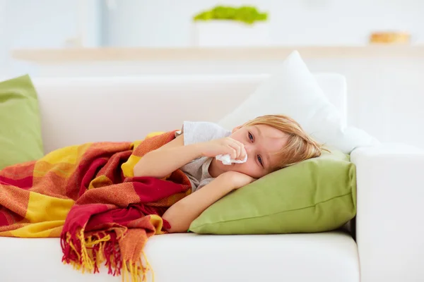 Criança doente com corrimento nasal e febre calor deitado no sofá em casa — Fotografia de Stock