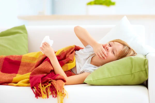 Sick kid with runny nose and fever heat lying on couch at home — Stock Photo, Image