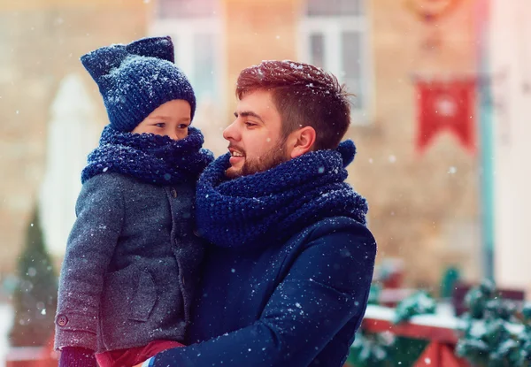 Familia feliz bajo las nevadas durante las vacaciones de invierno — Foto de Stock
