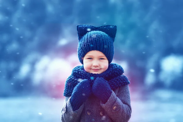Cute kid in knitted wear and felted coat under winter snow — Stock Photo, Image