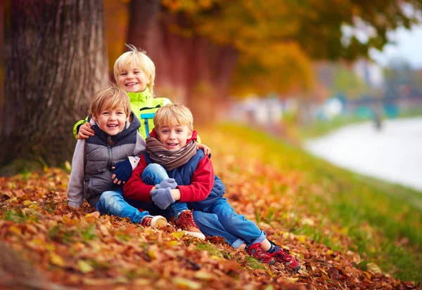 Tre bei bambini, amici insieme nel parco autunnale — Foto Stock