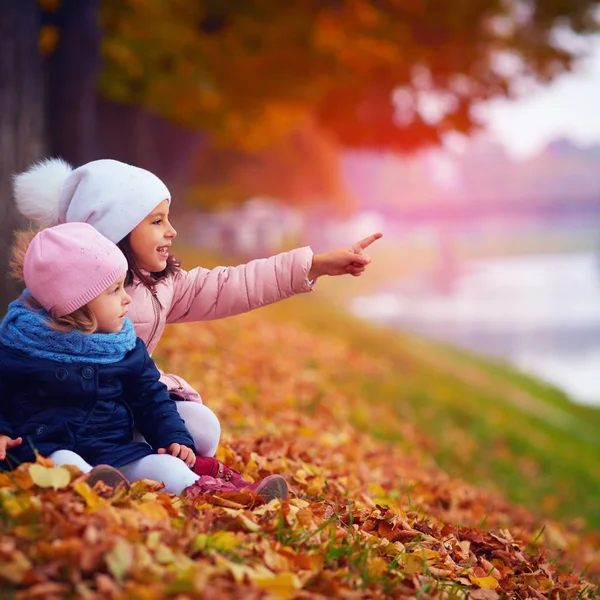 Due belle ragazze sedute nel parco autunnale — Foto Stock