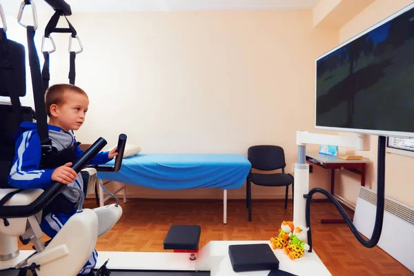 Un jeune garçon passe une thérapie robotique de la démarche dans un centre de réadaptation — Photo