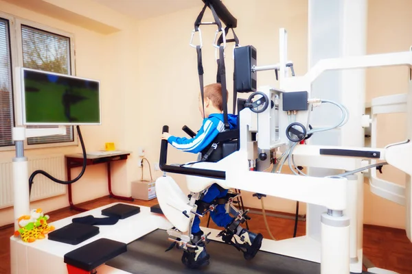 Young boy passes robotic gait therapy in rehabilitation center — Stock Photo, Image