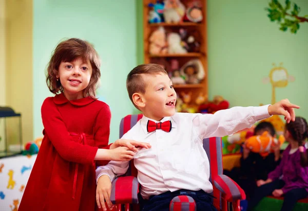 Schattige kleine man in de rolstoel en dame op vakantie in de kleuterschool voor kinderen met speciale behoeften — Stockfoto