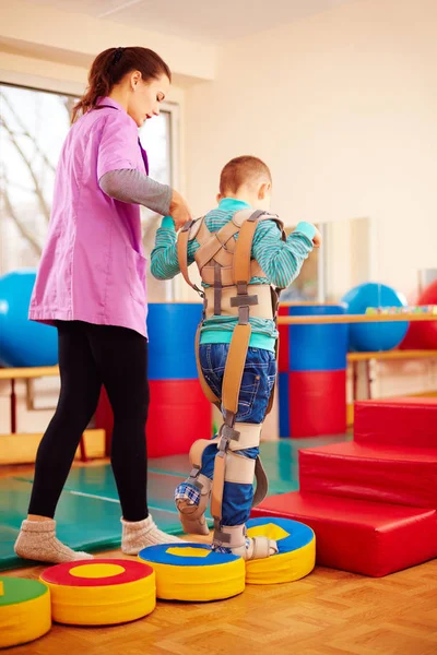 Cute kid having physical musculoskeletal therapy in rehabilitation center — Stock Photo, Image