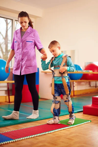 Cute kid having physical musculoskeletal therapy in rehabilitation center — Stock Photo, Image