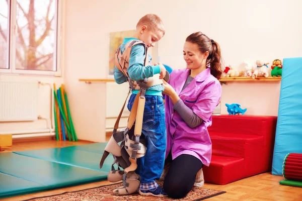 Cute kid is going to have physical musculoskeletal therapy in rehabilitation center — Stock Photo, Image