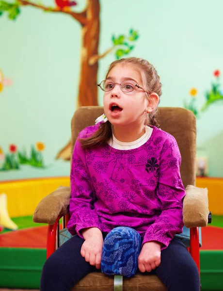 Menina bonita em cadeira de rodas no jardim de infância para crianças com necessidades especiais — Fotografia de Stock