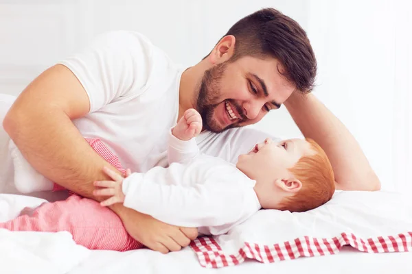 Gelukkig vader spelen met schattige baby in slaapkamer — Stockfoto