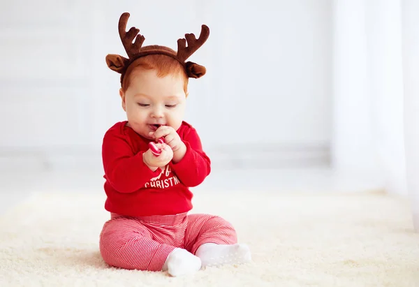 Leuk roodharige baby eten snoep kerst thuis — Stockfoto