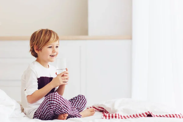 Młody dzieciak, chłopiec zaczyna jego rano, popijając szklanką wody słodkiej — Zdjęcie stockowe