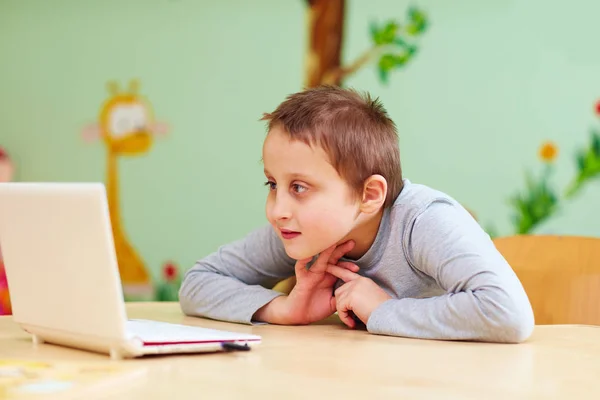 Video-den geçerek belgili tanımlık laptop izlerken özel ihtiyaçları olan genç çocuk — Stok fotoğraf
