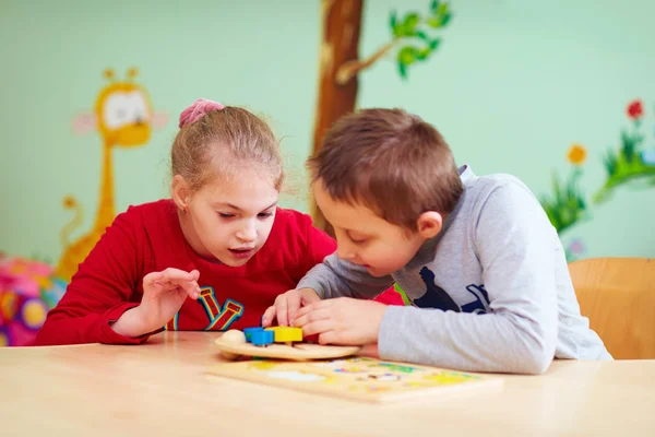 Niños con necesidades especiales desarrollan su motilidad fina en la guardería — Foto de Stock