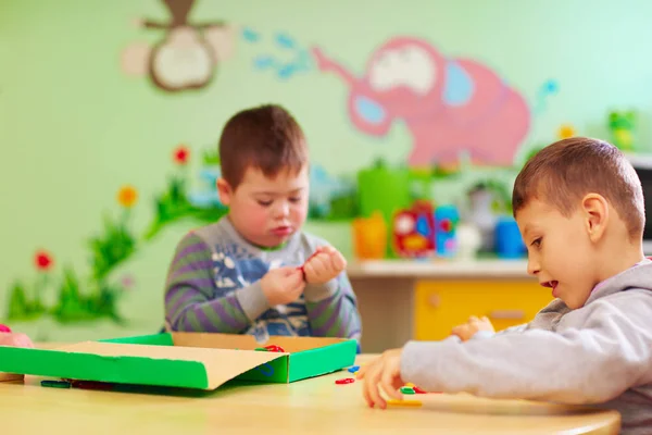 Kinder mit besonderen Bedürfnissen entwickeln ihre feinen Beweglichkeitsfähigkeiten in der Reha-Tagesstätte — Stockfoto